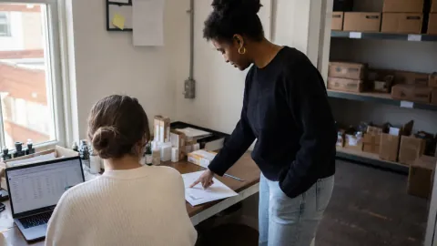 Deux collègues d'un petit laboratoire examinent un document près de leur réserve.
