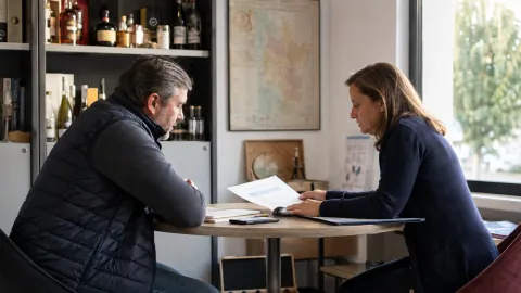 Une commerciale et un responsable de marque examinent un contrat dans un bureau.